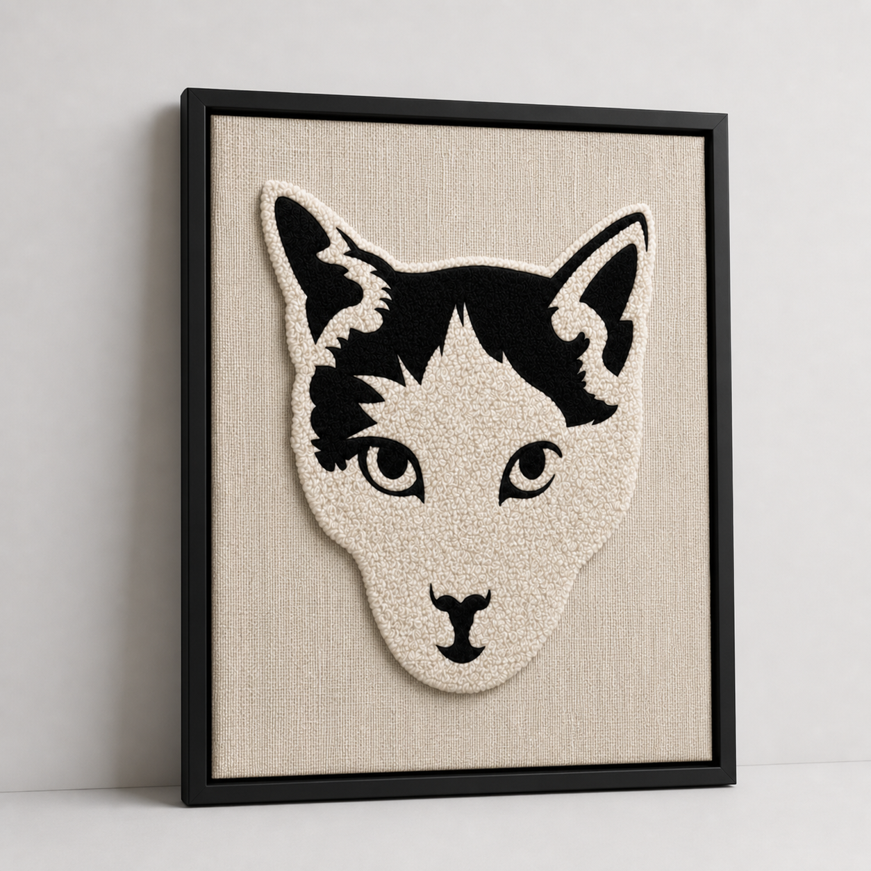 Framed fiber art cat portrait shown at an angle